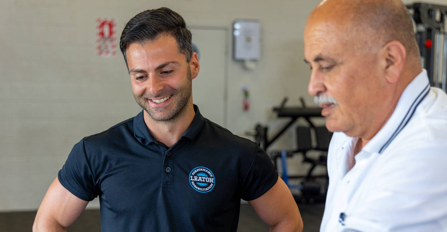 Robin Leaton standing with a client at Leaton Performance and Rehabilitation.