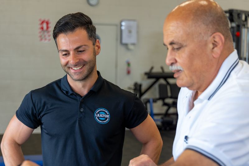 Robin Leaton standing with a client at Leaton Performance and Rehabilitation. 